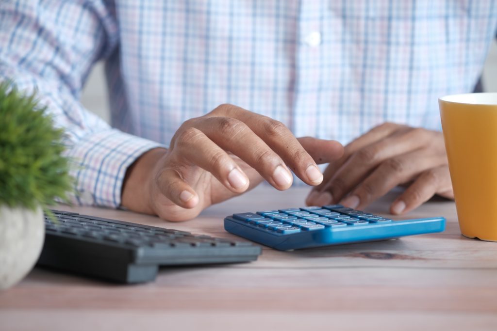 man calculating debt on calculator