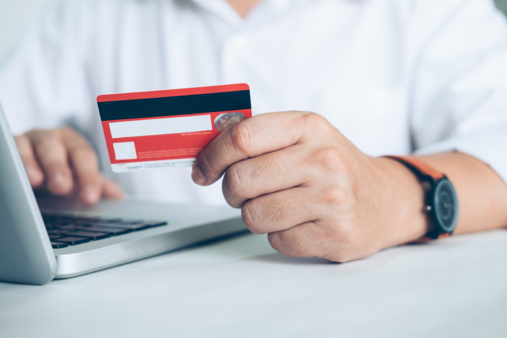 Man paying with credit card on laptop.